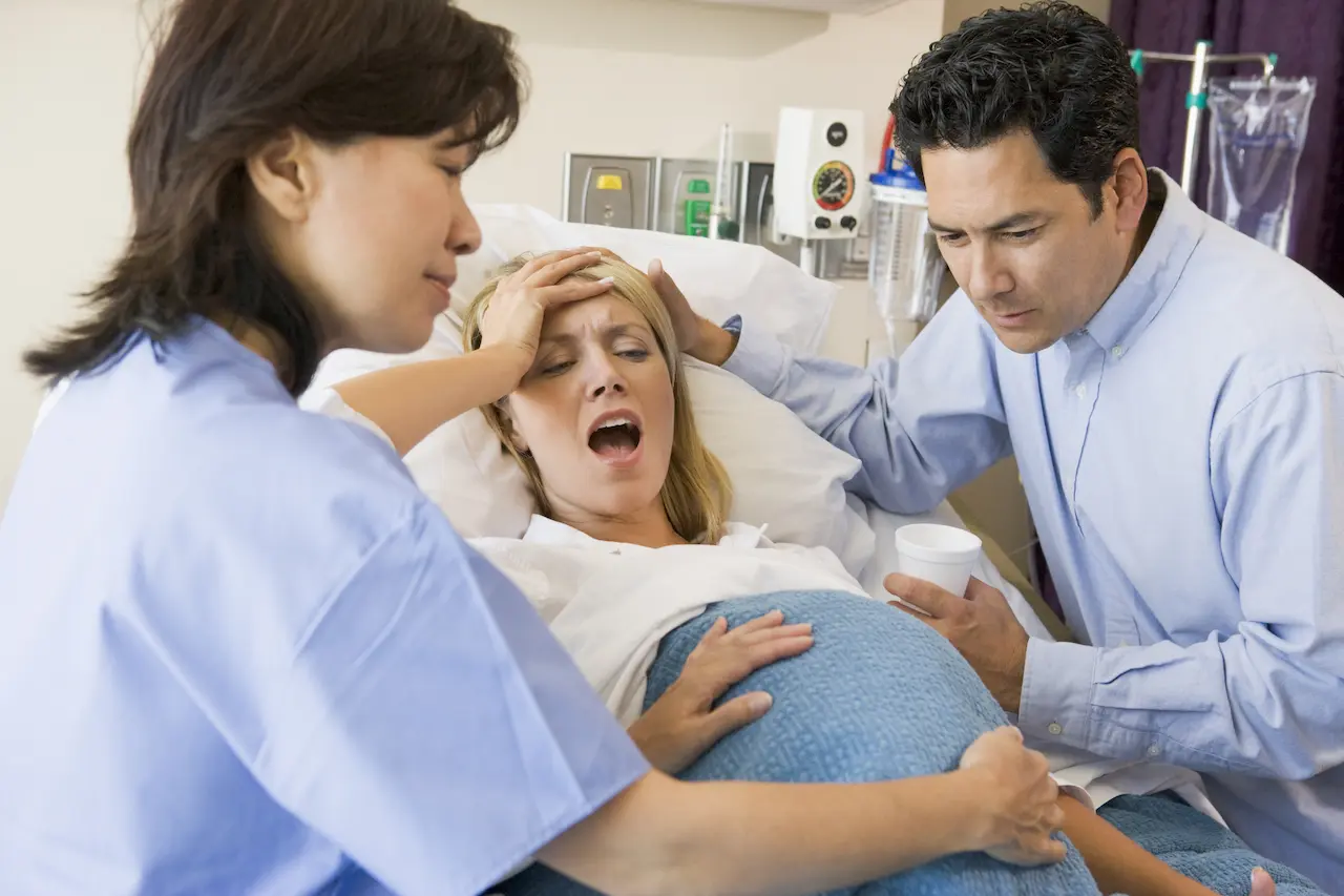 Woman Giving Birth In Maternity Ward