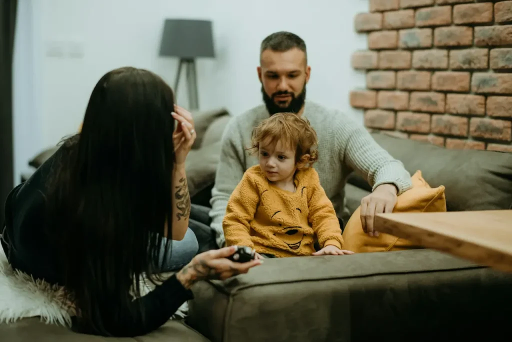 Divorced Parents Watching Their Baby On The Couch